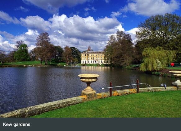 View across the lake at Kew Gardens with historic buildings and landscaped grounds
